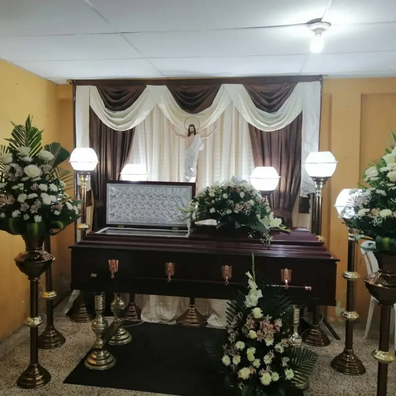 Altar con cortinas blancas y ataúd adornado