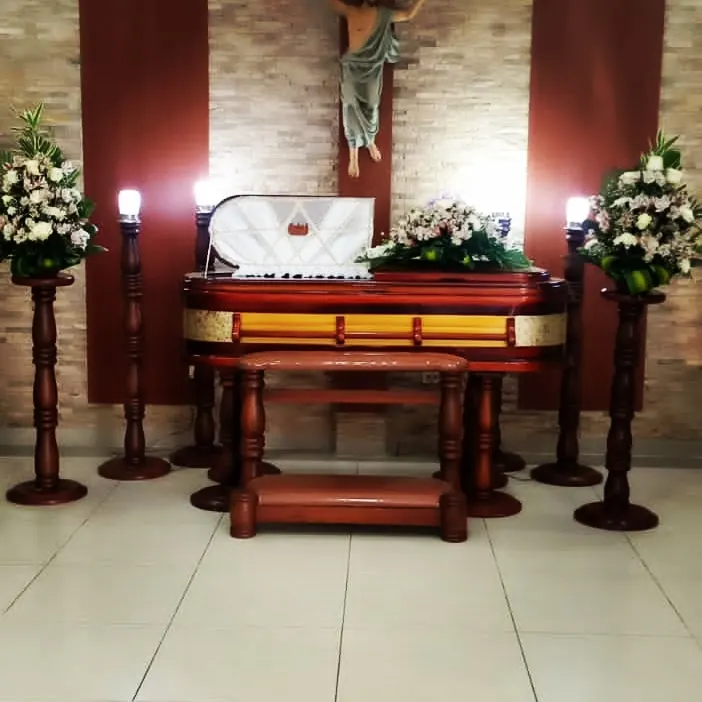 Ataúd adornado con candelabros en sala velatoria