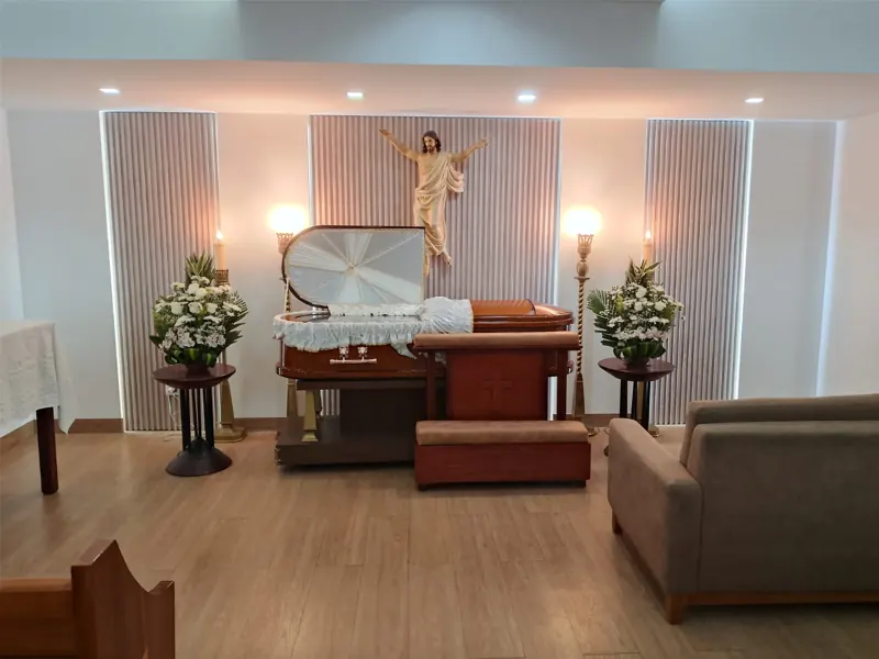 Sala velatoria moderna con imagen de Cristo y ataúd adornado