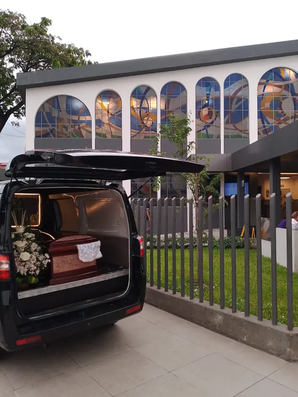 Carroza fúnebre con ataúd frente al vitral de nuestras instalaciones