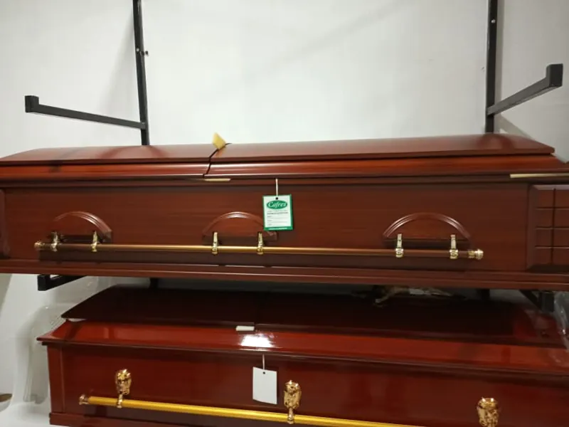 Ataúd de madera pulida con manijas doradas