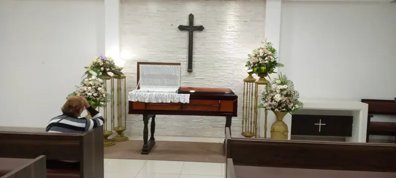 Sala velatoria con cruz y arreglos florales