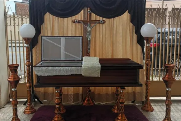 Ataúd adornado con velas en sala velatoria preparada para el servicio exequial